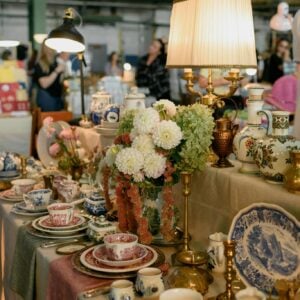 A display of vintage pottery and lamps at an antique market indoors.